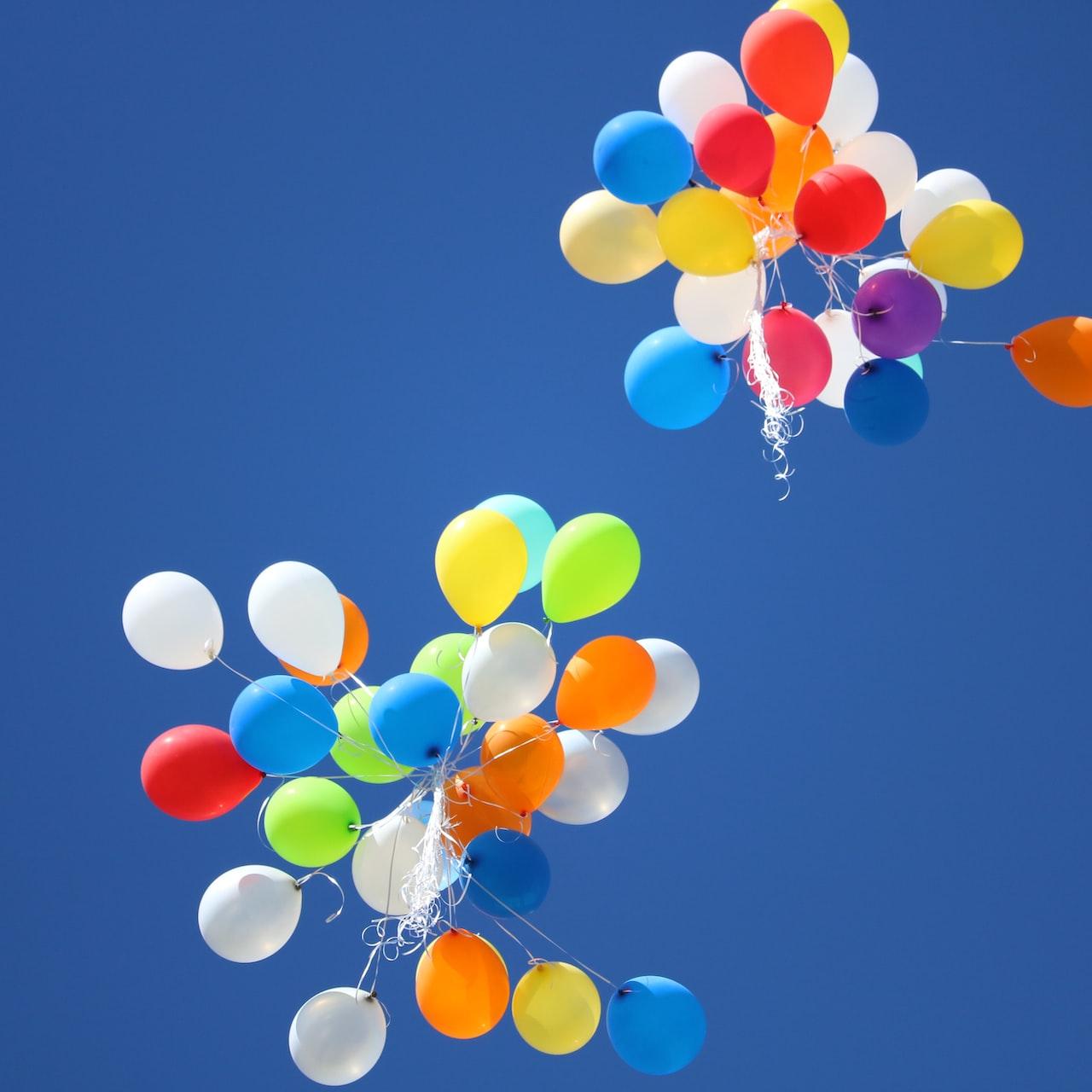 assorted-color balloons flying on sky during daytime