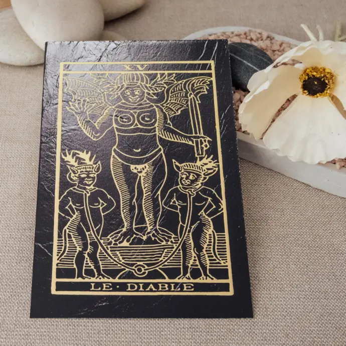Carte du tarot Le Diable – illustration du parfum du Tarot TSAEY, photographiée en mise en scène naturelle.